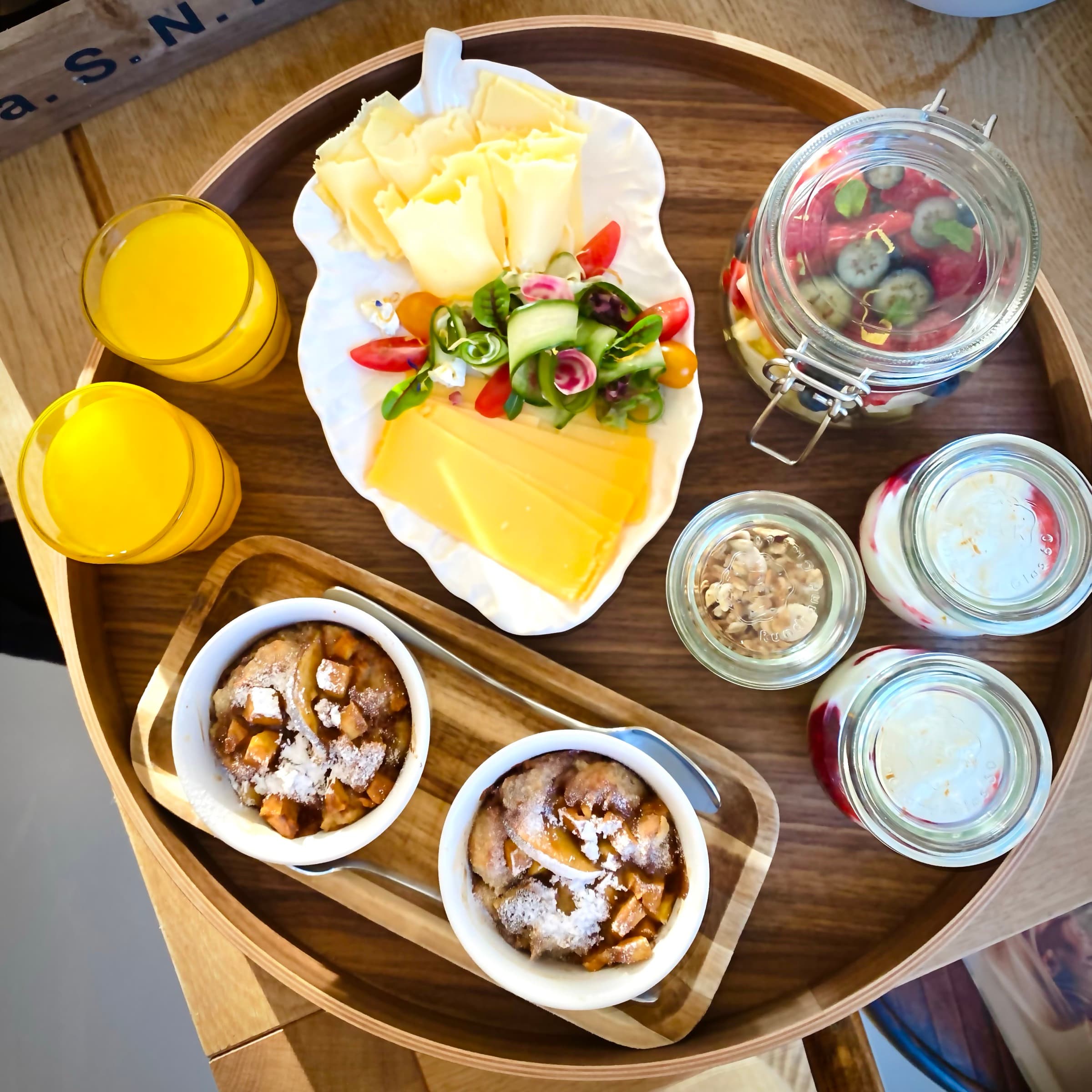 Homemade breakfast for two at Romantic Wellness B&B in Noordwijk, with cheese, vegetables, yoghurt, fruit, orange juice and warm apple dishes.